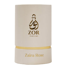 A cylindrical white box with gold accents, labeled "ZOR Parfums" featuring a stylized perfume bottle logo. Below, the name "Zaira Rose" is printed in gold letters, hinting at a luxurious fragrance infused with notes of honey and oud.